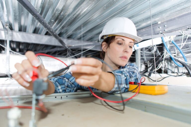 woman electrician tradie checking wires