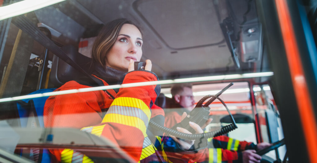 A firefighter speaks on the radio while in a fire truck.